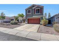 Charming two-story home with a well-maintained yard and a red garage door at 17426 W Calavar Rd, Surprise, AZ 85388