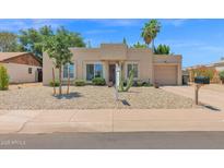 Charming home with low-maintenance desert landscaping, a barrel cactus, and a two-car garage at 3919 E Larkspur Dr, Phoenix, AZ 85032