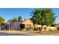 Charming single-story home with mature landscaping and a basketball hoop in the front at 5323 W North Ln, Glendale, AZ 85302