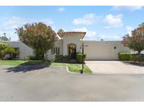 Charming single-story home with stucco exterior, red tile roof, gated courtyard and a well-manicured front yard at 7319 E Rose Ln, Scottsdale, AZ 85250