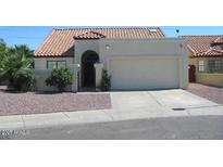 Charming single-story home featuring a stucco exterior, red tile roof, and desert landscaping at 7725 W Mcrae W Way, Glendale, AZ 85308