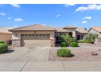 Charming single-story home featuring a well-manicured front yard with desert landscaping and a two-car garage at 14981 W Robson N Cir, Goodyear, AZ 85395