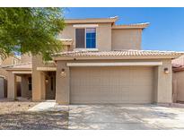 Two-story home with a beige exterior, well-kept landscaping, and a two-car garage and covered entry at 3910 W Goldmine Mountain Dr, San Tan Valley, AZ 85144