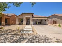 Charming single-story home with xeriscaped yard, covered porch, and convenient drive-through garage at 518 S 114Th Ave, Avondale, AZ 85323