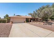 Charming single story home featuring a two-car garage, mature trees, and a well-maintained landscape at 5410 E Poinsettia Dr, Scottsdale, AZ 85254