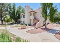 View of a condo building with stucco walls and a staircase leading to the upper level at 750 E Northern Ave # 2088, Phoenix, AZ 85020