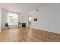 Bright living room features a fireplace, hardwood floors and large windows for natural light at 11640 N Tatum Blvd # 2012, Phoenix, AZ 85028