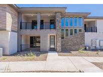 Stylish townhome with stone and stucco facade, private balcony, and sleek black metal railings at 2121 W Sonoran Desert Dr # 45, Phoenix, AZ 85085