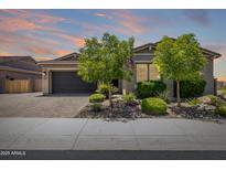 Charming single-story home with a two-car garage, desert landscaping and a paved driveway at 26314 N 103Rd Dr, Peoria, AZ 85383