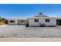 Charming single-story home with gravel front yard and a well-lit porch, perfect for relaxing outdoors at 3807 N 56Th Dr, Phoenix, AZ 85031