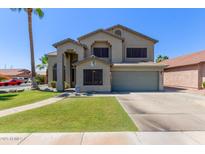 Two story home featuring desert landscaping, neutral color palette, and a two car garage at 4331 E Redwood Ln, Phoenix, AZ 85048