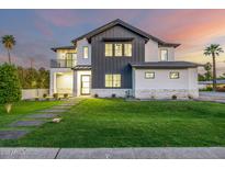 Stunning two-story home featuring a modern exterior, green lawn, and welcoming pathway to the front door at 4813 E Earll Dr, Phoenix, AZ 85018