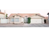 Charming single-story home with a well-manicured lawn, a two-car garage, and a welcoming front porch at 5515 E Elena Ave, Mesa, AZ 85206