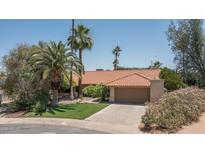 Charming single-story home with a tile roof, lush landscaping, and a two-car garage at 6101 E Beck Ln, Scottsdale, AZ 85254