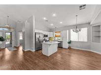 Bright kitchen boasts white cabinets, stainless appliances, island, and recessed lighting at 18119 W Spencer Dr, Surprise, AZ 85374