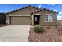 Charming single-story home with a two-car garage, desert landscaping, and a cozy covered entryway at 21999 E Wayward Ln, Red Rock, AZ 85145