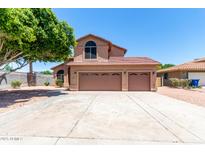 Charming home featuring a three-car garage, tiled roof, and low maintenance landscaping at 2213 N Ashbrook Cir, Mesa, AZ 85213