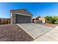 Beige home featuring a spacious garage with a long driveway and low maintenance desert landscaping at 3704 E Haflinger Rd, San Tan Valley, AZ 85140
