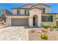 Charming two-story home featuring a two-car garage, a cozy porch, and desert landscaping at 40141 W James Ln, Maricopa, AZ 85138