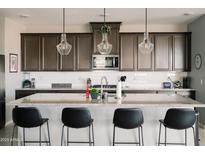 An open kitchen featuring granite countertops, stainless appliances, and modern pendant lighting at 4040 E Caitlin Dr, San Tan Valley, AZ 85140
