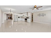Bright, open kitchen featuring white cabinetry, stainless steel appliances, and a seamless flow to the dining area with a cozy fireplace at 4154 W Morten Ave, Phoenix, AZ 85051