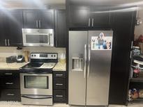 Well-appointed kitchen features stainless steel appliances and dark cabinetry, providing ample storage at 5110 N 42Nd Dr, Phoenix, AZ 85019