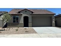 Charming single-story home featuring a tile roof, two-car garage, and low maintenance desert landscaping at 5645 S 253Rd Ave, Buckeye, AZ 85326