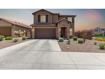 Two-story home showcasing stone accents, a two-car garage, and low-maintenance desert landscaping at 7123 W Andrea Dr, Peoria, AZ 85383