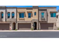 Modern townhomes with attached garages, neutral stucco, and arched entryways exude contemporary charm at 7492 E Via De Luna Dr, Scottsdale, AZ 85255
