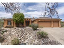 Warm, inviting home featuring a three-car garage and desert landscaping at 8698 E Preserve Way, Scottsdale, AZ 85266