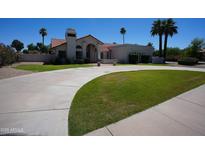 Elegant single-story home with a spacious driveway and manicured lawn at 9505 E Jenan Dr, Scottsdale, AZ 85260