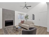 Cozy living room featuring a fireplace, ceiling fan, and neutral furnishings at 1075 E Chandler Blvd # 212, Chandler, AZ 85225