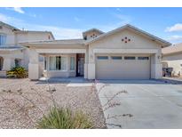 Charming single-story home featuring a two-car garage, desert landscaping, and a covered front porch at 11630 W Jefferson St, Avondale, AZ 85323