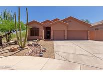 Charming single-story home with a two-car garage and desert landscaping at 14657 N 103Rd Way, Scottsdale, AZ 85255