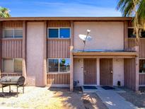 Tan two-story townhouse with brown trim, security doors, and a small front yard at 1750 E Mateo Cir # 103, Mesa, AZ 85204