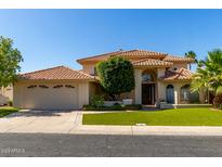 Charming two-story home featuring a tile roof, manicured lawn, and an attached three-car garage at 1834 E Willow Tree Ct, Gilbert, AZ 85234
