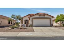 Charming single-story home featuring a two-car garage, terracotta tile roof, and desert landscaping at 23075 W Arrow Dr, Buckeye, AZ 85326