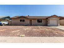 Charming single-story home featuring an attached garage and low maintenance front yard at 233 E 7Th Dr, Mesa, AZ 85210
