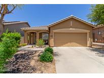 Charming single-story home featuring a well-manicured front yard and a two-car garage at 2458 W Warren Dr, Anthem, AZ 85086