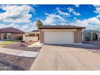 Home featuring a two-car garage, desert landscaping and brick accents on a sunny day at 4016 W Royal Palm Rd, Phoenix, AZ 85051