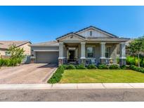 Charming home exterior featuring a covered porch, landscaped yard and brick driveway at 4442 E Fairbrook St, Mesa, AZ 85205