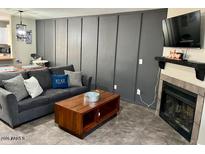 Cozy living room features a gray sofa, wooden coffee table, and decorative board and batten wall at 4601 N 102Nd Ave # 1052, Phoenix, AZ 85037
