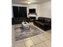 Cozy living room with a fireplace, tile floors, a coffee table and two sofas at 4601 N 102Nd Ave # 1194, Phoenix, AZ 85037