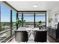 Bright home office featuring a modern desk and a wall of windows offering stunning city views at 4808 N 24Th St # 1228, Phoenix, AZ 85016