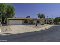 Charming home featuring a well-manicured front yard, covered entry, and attached two-car garage at 5148 E Edgewood Cir, Mesa, AZ 85206