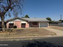 Charming single-story home featuring a pink exterior, attached garage, and well-manicured front yard at 6231 N 25Th Ave, Phoenix, AZ 85015