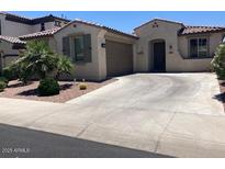 Charming single-story home featuring a well-manicured lawn and a two-car attached garage at 9141 W Dreyfus Dr, Peoria, AZ 85381