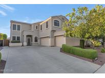 Spacious two-story stucco home featuring a three-car garage, landscaped yard, and concrete driveway at 9582 W Albert Ln, Peoria, AZ 85382