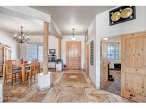 Inviting foyer with a wood door, decorative tile flooring, and an open layout to the adjacent dining area at 1032 E Dolores Rd, Phoenix, AZ 85086