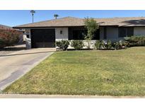 Charming single-story home boasts a well-manicured lawn, complemented by desert landscaping and a brick-accented facade at 11133 W Cameo Dr, Sun City, AZ 85351